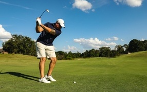 Мужчина занимается гольфом на поле