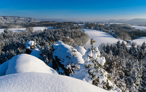 View from the mountain to the snow-covered forest and the river