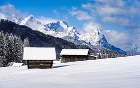 Wooden snow-covered houses in the mountains