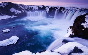 Snow-covered shores of Godafoss waterfall, Iceland