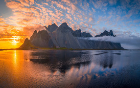 Солнце садится за горой в море, Исландия