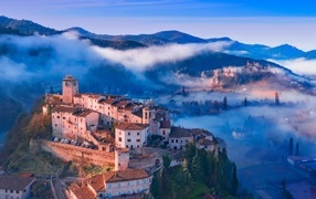 Вид на город на горе в тумане, Италия