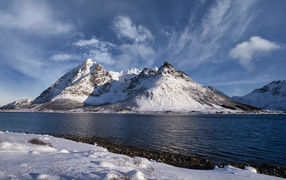 Покрытые снегом горы у озера, Норвегия