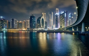 Night skyscrapers are reflected in the water, Dubai. UAE