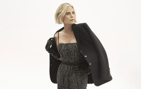 Actress Charlize Theron in a dress posing on a white background