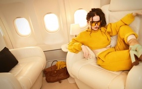 Актриса Дав Кэмерон в желтом костюме в самолете