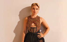 Actress Florence Pugh in a dress poses against a wall