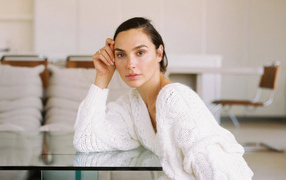 Actress Gal Gadot in a white sweater at the table
