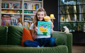 Актриса Натали Дормер  с книгой в руках на диване