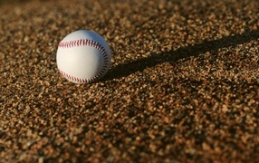 Бейсбольный мяч в лучах солнца на асфальте