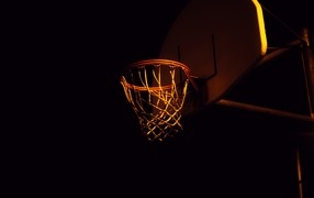 Basketball hoop in rays of light at night