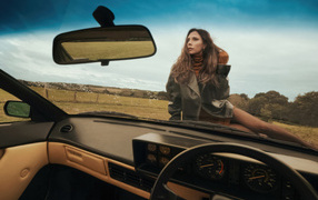 Beautiful girl Victoria Beckham sits on a car