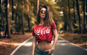 Красивая стройная девушка в футболке кока кола