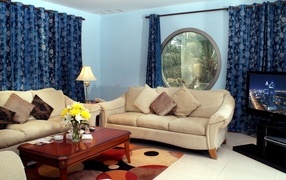 Blue curtains in a living room with two sofas