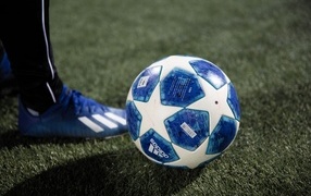 Синий футбольный мяч на зеленой траве поля
