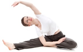 Девушка занимается йогой на белом фоне