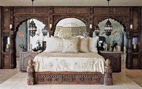 Large wooden bed in a room with carved walls