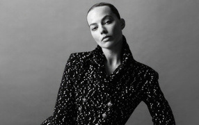 Грустная Марго Робби в блестящем пиджаке на сером фоне