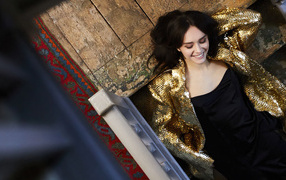 Улыбающаяся актриса Оливия Кук в черном платье