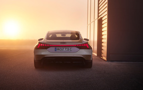 Вид сзади на автомобиль Audi RS E-Tron GT Prototype на фоне солнца