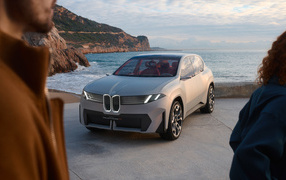 Серебристый автомобиль BMW Vision Neue Klasse X 2024 года у воды