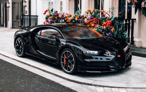 Черный автомобиль Bugatti Chiron у здания