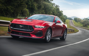 Красный автомобиль  Ford Mustang GT Performance 2024  года на дороге