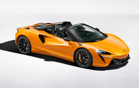 Оранжевый автомобиль McLaren Artura Spider на сером фоне