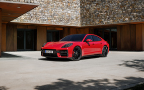 Красный автомобиль Porsche Panamera GTS 2024 года у здания