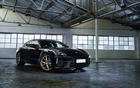 Черный автомобиль Porsche Panamera 2024  года в ангаре