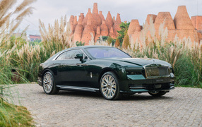 Дорогой зеленый автомобиль Rolls-Royce Spectre