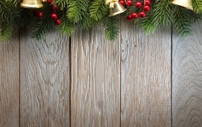 Деревянный новогодний фон с еловой веткой и колокольчиками