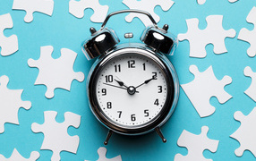 Будильник на голубом фоне с пазлами