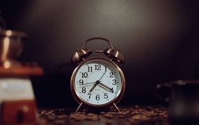 Будильник на столе с зернами кофе