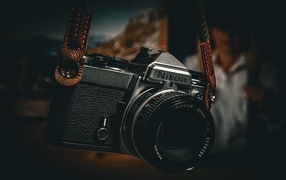 Черный фотоаппарат nikon на ремне