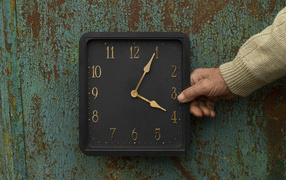 Черные квадратные часы на старой стене