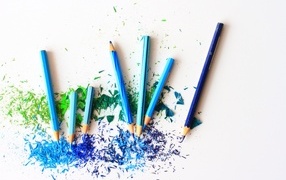 Синие заточенные карандаши со стружкой на белом фоне