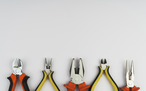 Different pliers on a gray background