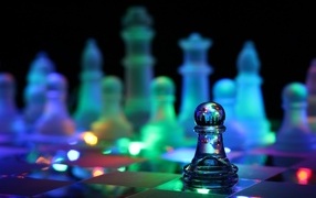 Стеклянные шахматы с гирляндой лежат на доске