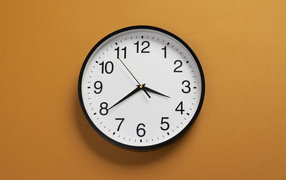 Большие круглые часы на желтом фоне