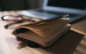 Блокнот с ручкой на столе