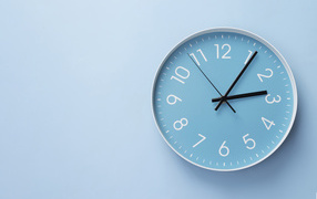 Круглые часы на голубом фоне крупным планом