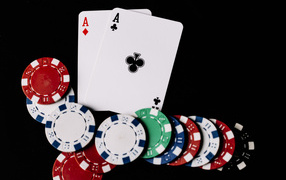Two aces and poker chips on a black background