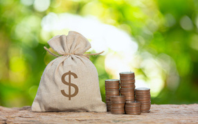 Мешок с деньгами на столе с монетами