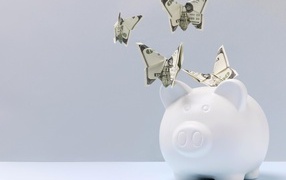 Свинья копилка с бабочками из купюр на сером фоне