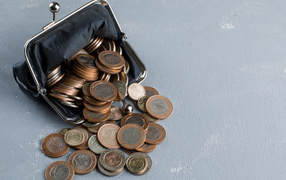 Кошелек с монетами на сером столе