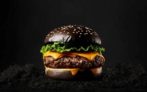 Большой сочный черный гамбургер крупным планом