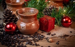 Кофейные зерна на столе с посудой и еловой веткой