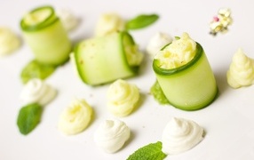 Рулетики из огурца с кремом на белом фоне