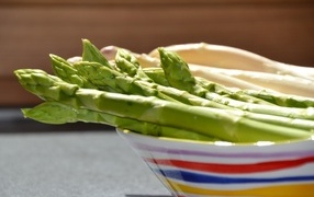 Зеленая спаржа в тарелке на столе